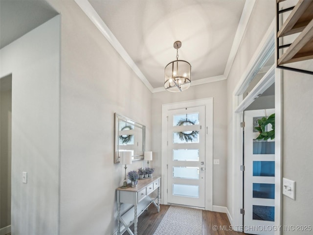 entryway with crown molding, baseboards, dark wood finished floors, and a chandelier