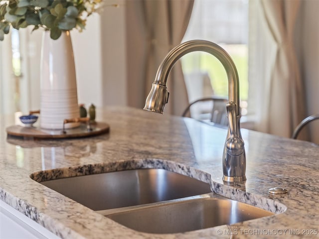 interior details with stone countertops and a sink