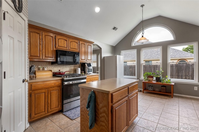 3933 S 199th E Ave, Broken Arrow, OK 74014 - kitchen with black microwave, stainless steel gas range oven, freestanding refrigerator, and brown cabinets
