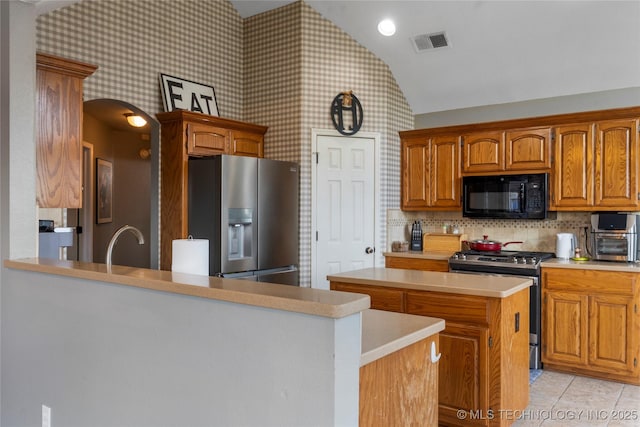 3933 S 199th E Ave, Broken Arrow, OK 74014 - kitchen featuring visible vents, lofted ceiling, a kitchen island, light countertops, and appliances with stainless steel finishes