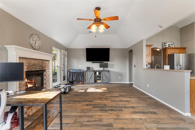 3933 S 199th E Ave, Broken Arrow, OK 74014 - living room with a brick fireplace, wood finished floors, arched walkways, a ceiling fan, and vaulted ceiling