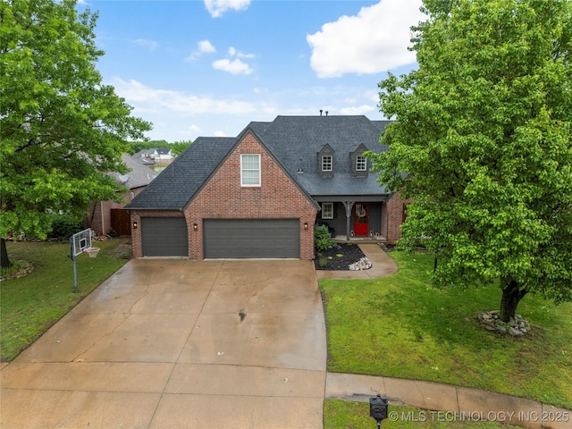 view of front facade featuring brick siding, a garage, a front lawn, and driveway