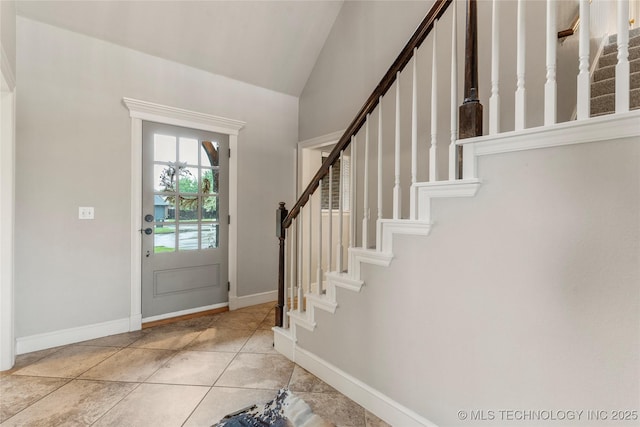 entryway featuring stairway, baseboards, and lofted ceiling
