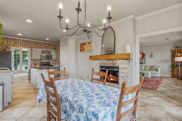 dining area featuring crown molding, brick wall, a fireplace, baseboards, and recessed lighting