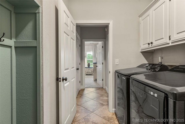 laundry room with baseboards, cabinet space, light tile patterned floors, and washer and dryer