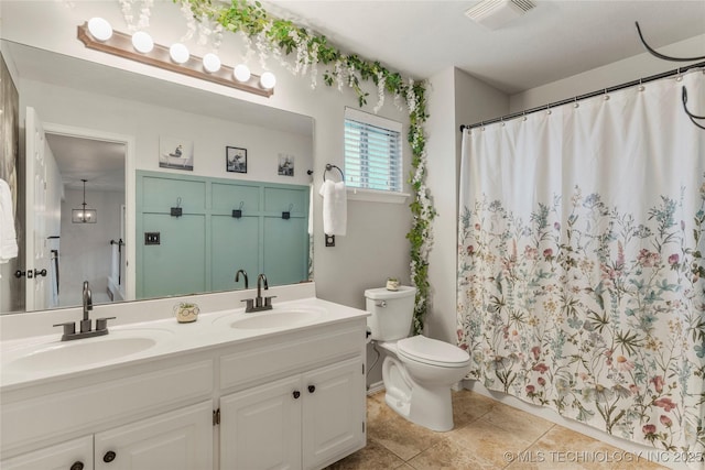 full bathroom with a sink, toilet, double vanity, and visible vents