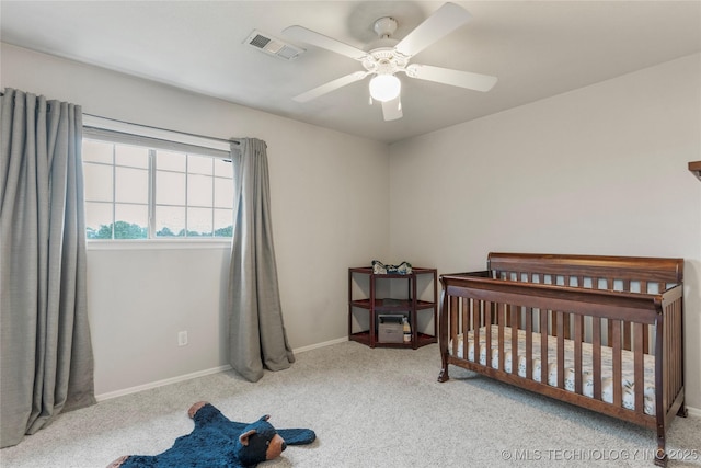 bedroom with visible vents, carpet floors, baseboards, ceiling fan, and a nursery area