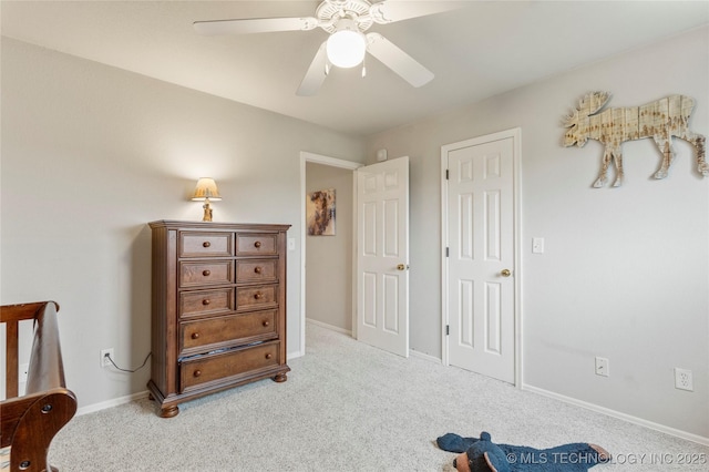 carpeted bedroom featuring baseboards and a ceiling fan
