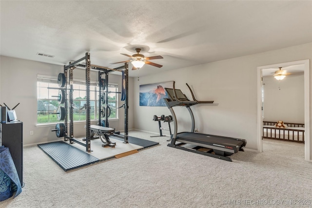 exercise room featuring visible vents, carpet flooring, baseboards, and ceiling fan
