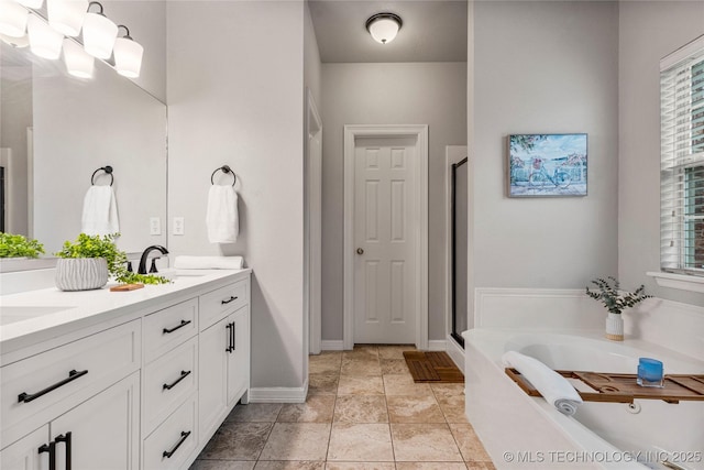 bathroom with double vanity, a shower stall, a sink, and a bath