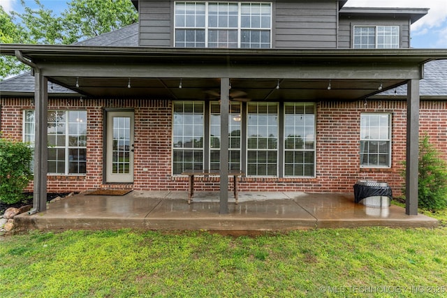 rear view of property with a patio area and brick siding