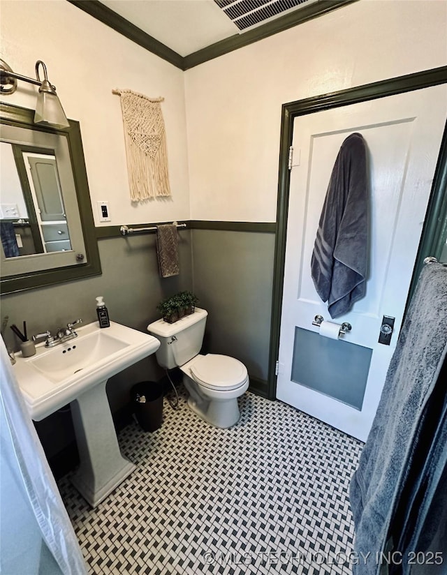 bathroom featuring crown molding, tile patterned floors, toilet, and visible vents
