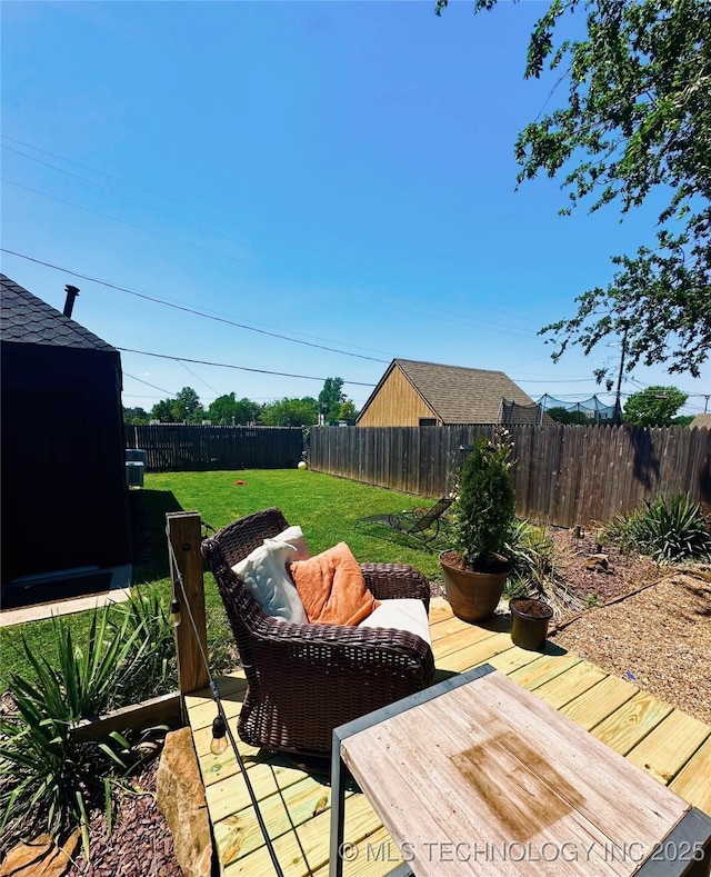 wooden deck with a lawn and a fenced backyard
