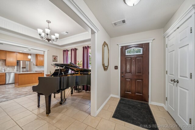 9998 E 460th Rd, Claremore, OK 74017 - entrance foyer with a chandelier, light tile patterned floors, and baseboards