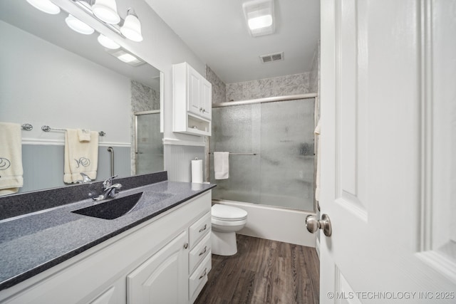 9998 E 460th Rd, Claremore, OK 74017 - full bath with wood finished floors, vanity, toilet, and shower / bath combination with glass door