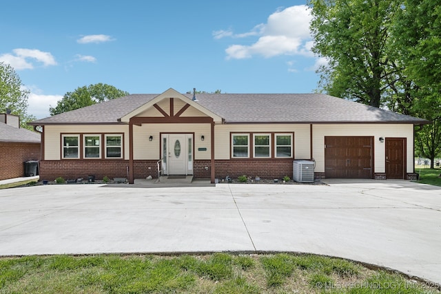 9998 E 460th Rd, Claremore, OK 74017 - view of front of house with an attached garage, concrete driveway, brick siding, and central air condition unit