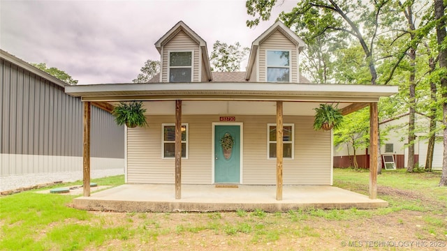 view of front of property featuring covered porch and a front yard