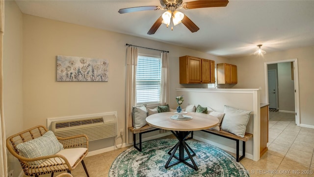 dining area with baseboards, a ceiling fan, a wall unit AC, and light tile patterned flooring