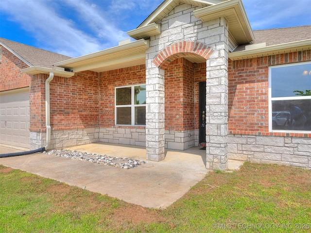 doorway to property featuring roof with shingles, an attached garage, and brick siding