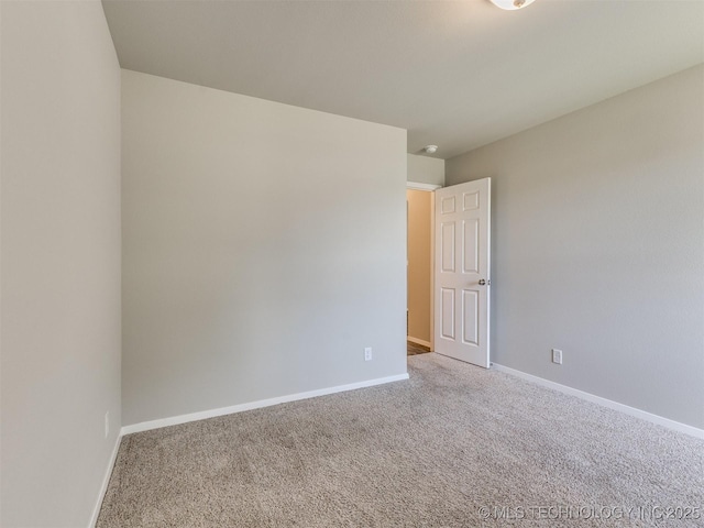 carpeted spare room with baseboards