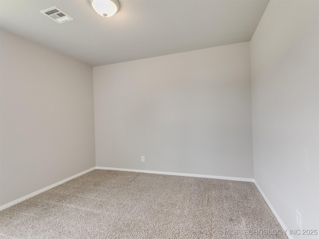 unfurnished room with carpet, visible vents, and baseboards