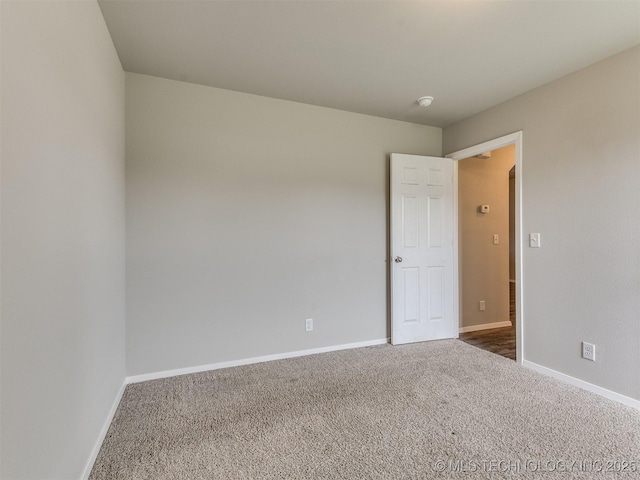 carpeted spare room with baseboards