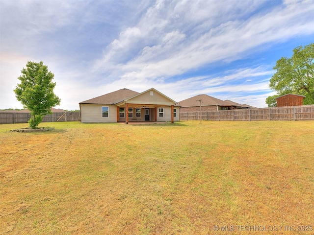 rear view of house with a lawn, a patio, and a fenced backyard