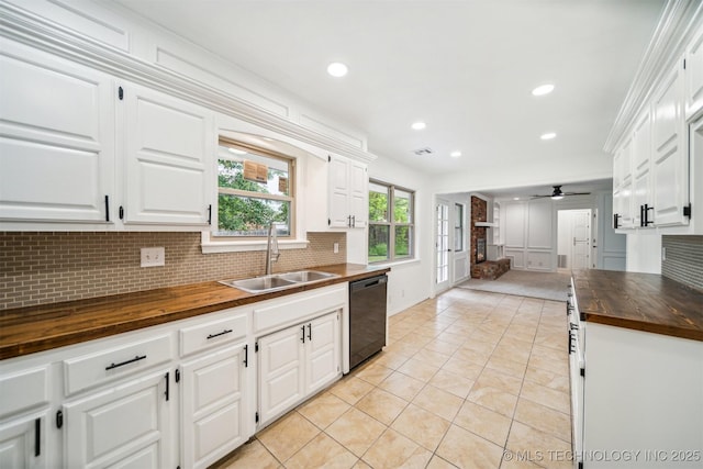 kitchen featuring wood counters, tasteful backsplash, a sink, and dishwasher