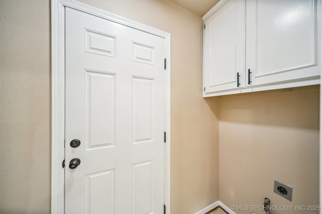 washroom with baseboards, cabinet space, and hookup for an electric dryer