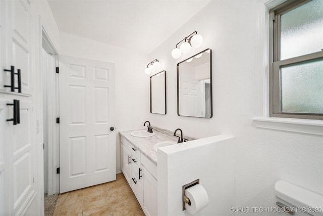 bathroom featuring plenty of natural light, a sink, and toilet