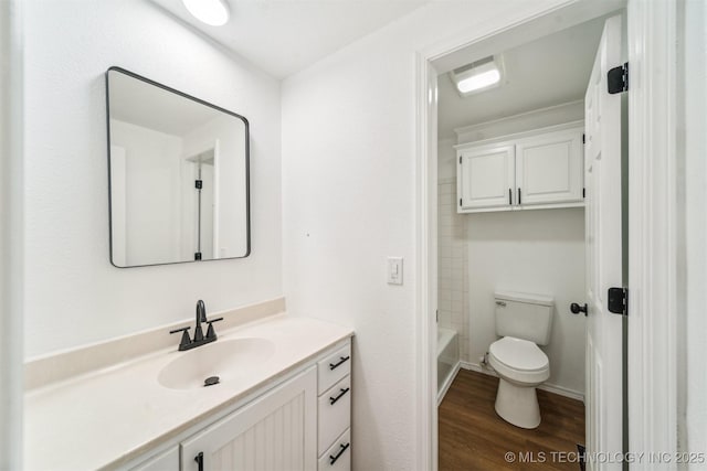 bathroom with toilet, wood finished floors, and vanity