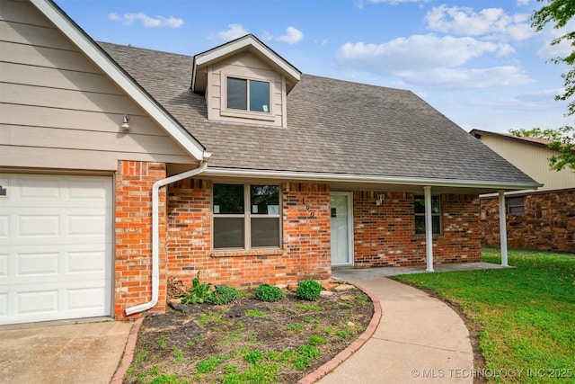 view of front of home featuring brick siding, a shingled roof, a front lawn, and concrete driveway