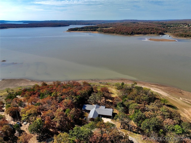 drone / aerial view featuring a water view and a view of trees
