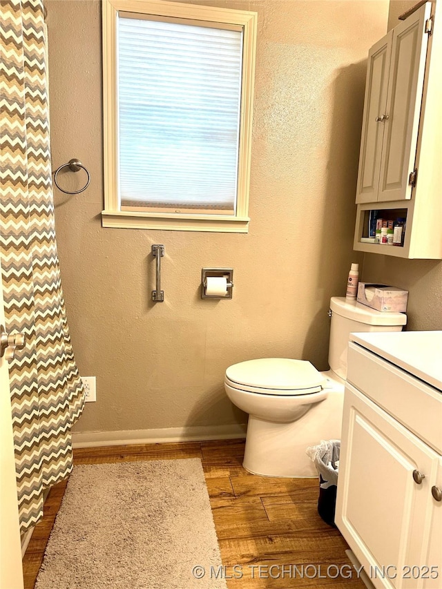 1082 Gaines Creek Loop, Eufaula, OK 74432 - bathroom with toilet, wood finished floors, vanity, curtained shower, and a textured wall