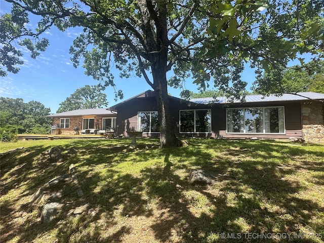 1082 Gaines Creek Loop, Eufaula, OK 74432 - rear view of house featuring stone siding, a lawn, and a wooden deck