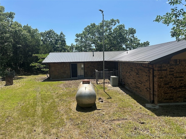 1082 Gaines Creek Loop, Eufaula, OK 74432 - back of property with a lawn, central air condition unit, metal roof, and stone siding