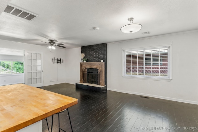 living area featuring visible vents, baseboards, ceiling fan, and dark wood-style flooring