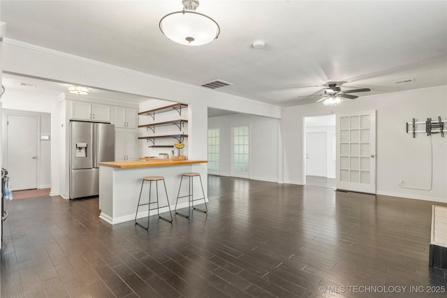 living room featuring baseboards, ceiling fan, dark wood-style flooring, and visible vents