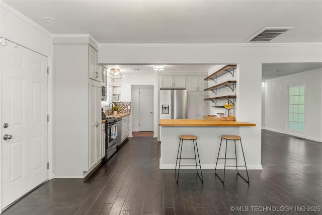 kitchen featuring a kitchen breakfast bar, dark wood-style flooring, open shelves, stainless steel appliances, and butcher block countertops