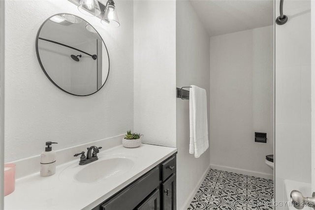 bathroom with toilet, baseboards, tile patterned floors, and vanity