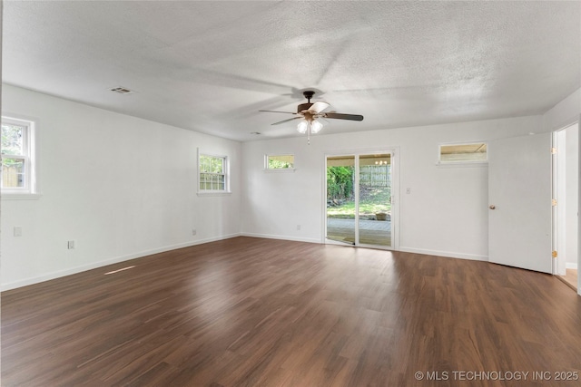 spare room with a textured ceiling, ceiling fan, dark wood-style floors, and baseboards