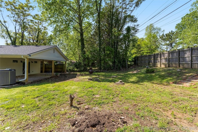 view of yard with a patio, central AC unit, and fence