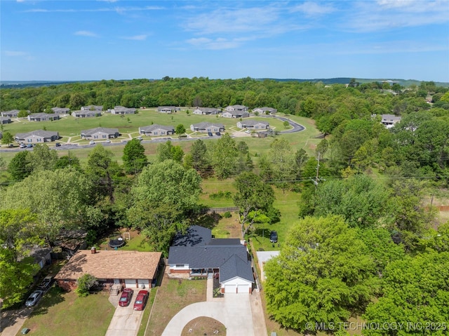 bird's eye view with a wooded view