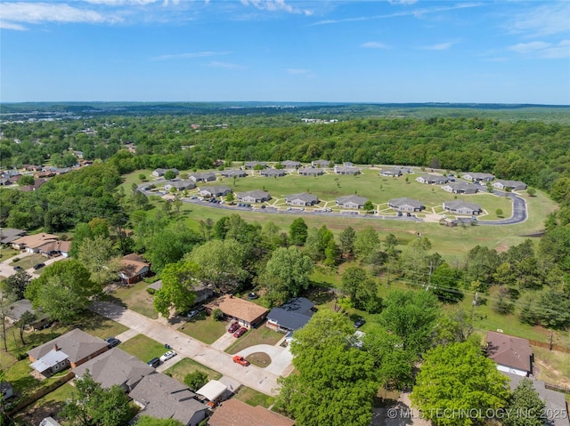 drone / aerial view featuring a forest view and a residential view