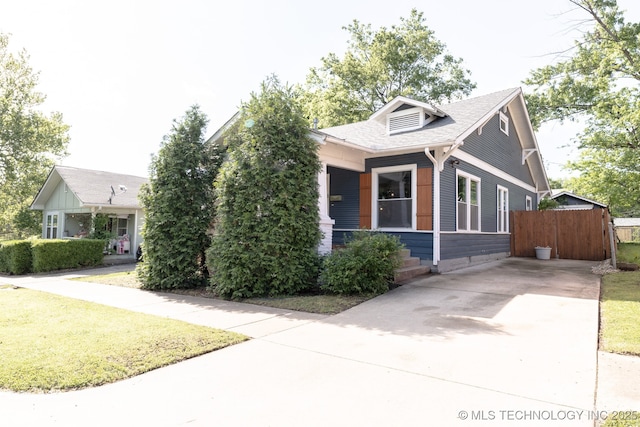 1304 W Easton St, Tulsa, OK 74127 - view of front of home with fence, roof with shingles, a front yard, concrete driveway, and covered porch