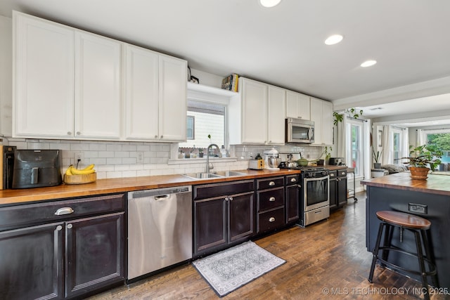1304 W Easton St, Tulsa, OK 74127 - kitchen with a healthy amount of sunlight, white cabinets, a sink, wood counters, and stainless steel appliances