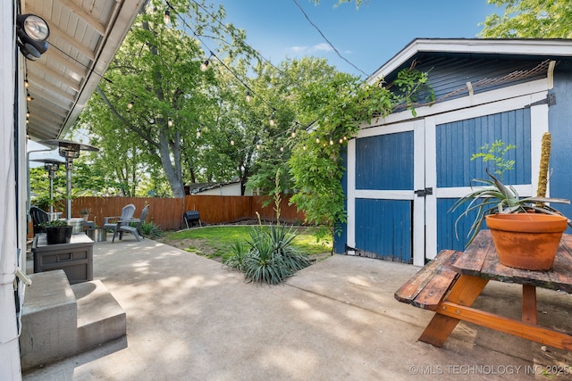 1304 W Easton St, Tulsa, OK 74127 - view of patio featuring a fenced backyard, a shed, and an outbuilding