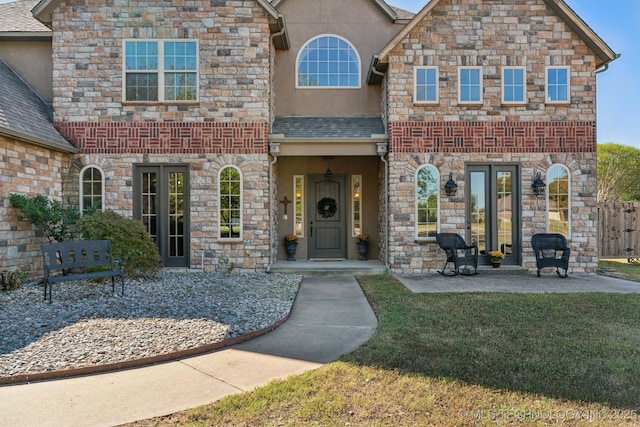view of front of property featuring fence, stucco siding, a shingled roof, and a front lawn