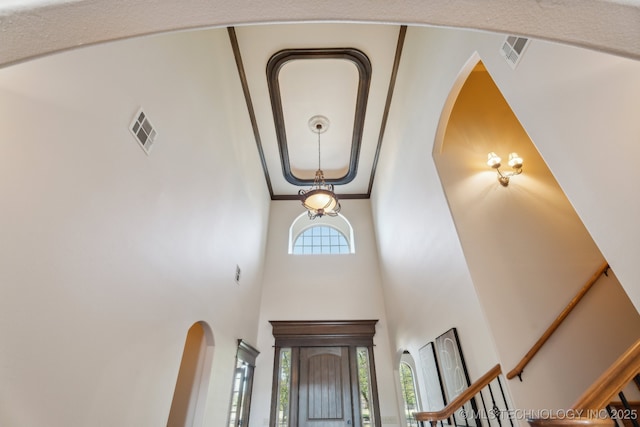 entrance foyer with visible vents, arched walkways, and a high ceiling