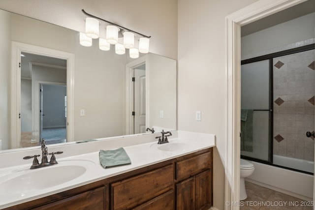 bathroom featuring double vanity, toilet, a sink, and tile patterned flooring
